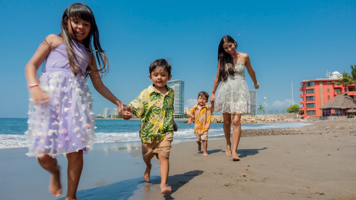 Cheerful family playing and running on a sunny beach, enjoying a vacation day together.